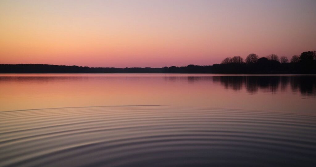 Warm sunset reflecting over a quiet lake representing rest and restoration in burnout therapy